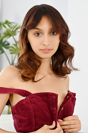 Ashly Rabbit teases in white underwear and red shirt, posing solo on office table with plant backdrop