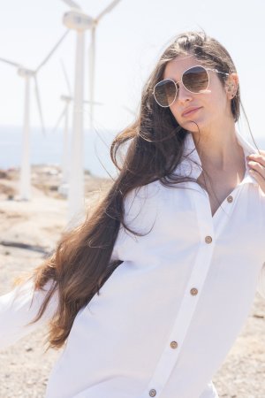 Esfinge bares all on a rocky shore her white shirt slipping as ocean wind teases her curves — Esfinge #1