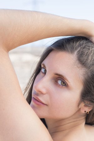 Esfinge bares all on a rocky shore her white shirt slipping as ocean wind teases her curves — Esfinge #19