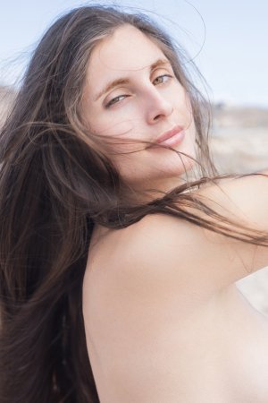 Esfinge bares all on a rocky shore her white shirt slipping as ocean wind teases her curves — Esfinge #20