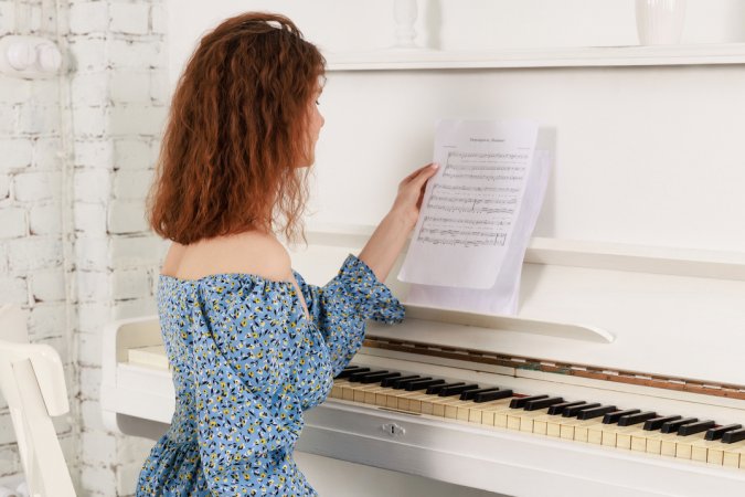 Lilliana bends over the piano in lace thong, blue skirt hiked high, showcasing her curves in white brick bedroom — Lilliana #2