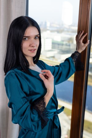 Posy teases in sheer lingerie and teal robe by the window, morning light on her curves — Posy #2