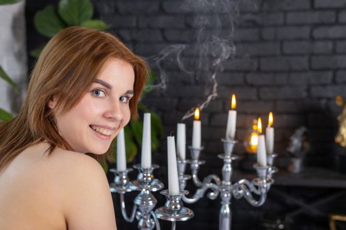 Mari A kneeling by the table then sliding down her dress to pose bare on the leather couch — Mari A #24