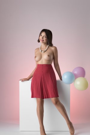 Olivia Linz nude solo posing with pearls and balloons on white cube against pink Sixties backdrop — Olivia Linz #1
