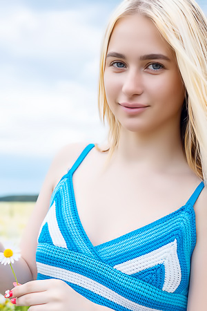 Melisa A posing nude in a daisy field, blue wrap slipping as she spreads her legs for the camera