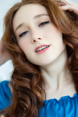 Alice Mido in blue silk, topless posing on wicker chair, curly redhead teasing her curves