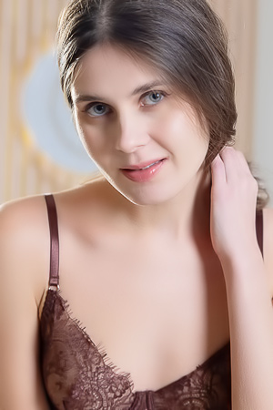 Luna Moonie posing in lace lingerie on a comfy sofa, kneeling, lying and smiling for the camera