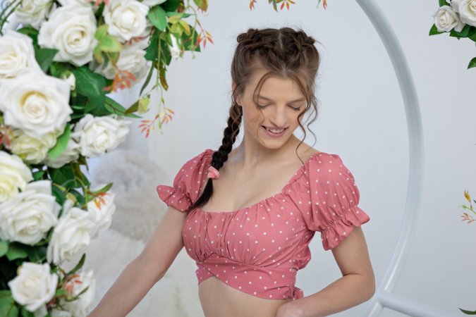 Aphilia stripping pink lace on white fur, floral arch framing her solo tease and nude poses — Aphilia #2