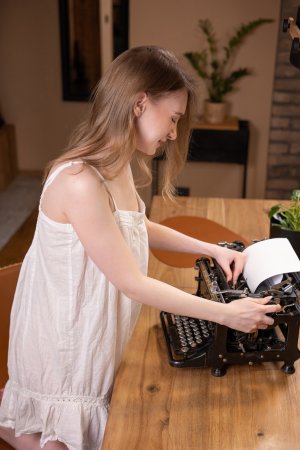 Febe posing nude on a wooden table beside a typewriter in her Love Letters solo session — Febe #1